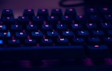 focus photography of computer keyboard with red lights