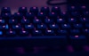 focus photography of computer keyboard with red lights