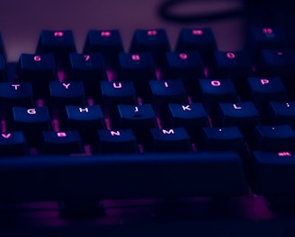 focus photography of computer keyboard with red lights