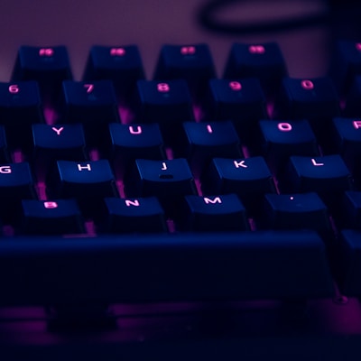 focus photography of computer keyboard with red lights