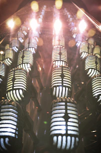 Precision measurement microphones arranged neatly with subtle blue lighting highlighting their contours.