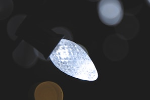 High-resolution shot of a smart bulb featuring a smooth, futuristic design with vibrant light effects in cyan and amber.