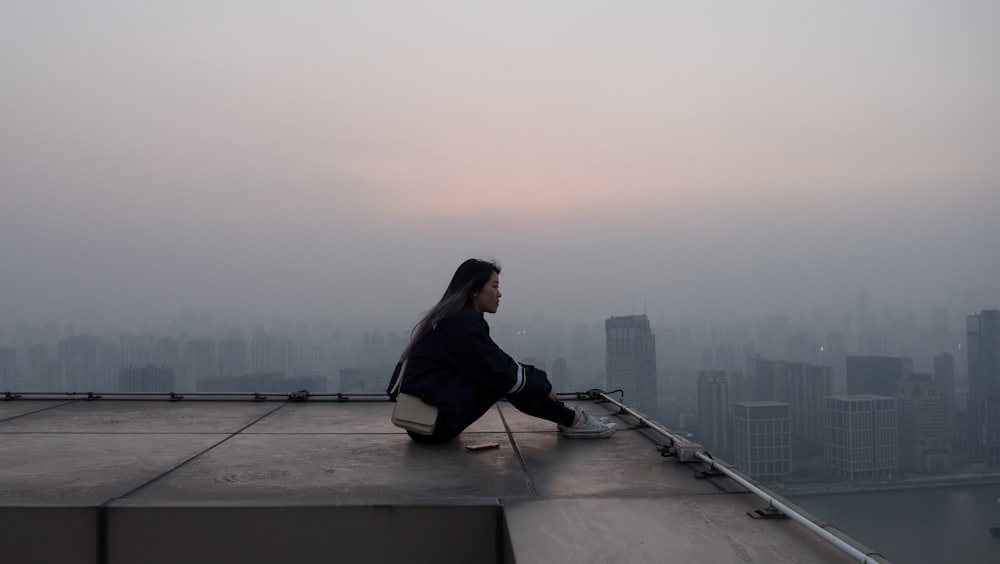 woman seating on skyscraper