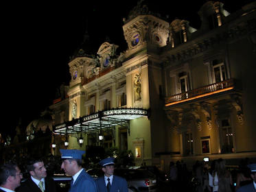 A lively scene outside a grand theatre in London, with guests dressed for an evening of world-class performance.