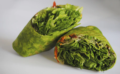 Close-up of a reusable beeswax food wrap covering fresh vegetables.