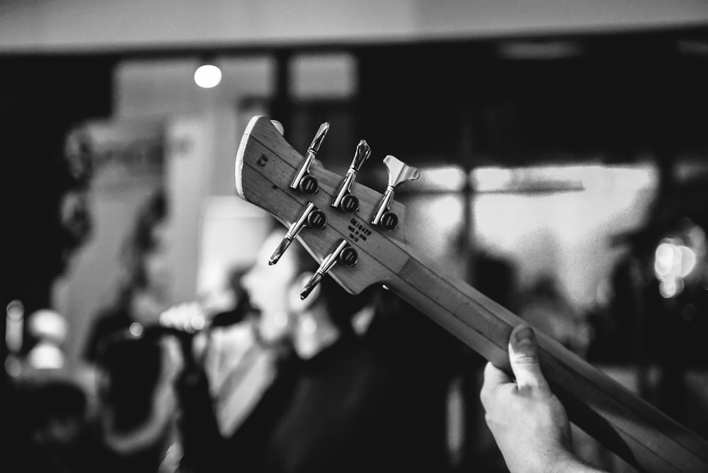 grayscale photo of person playing guitar