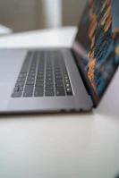 A sleek laptop displaying the Виртуоз online casino homepage