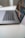 A sleek laptop is partially open on a clean, white surface, with a focus on the keyboard and touchpad. The screen displays a vibrant, digital image with abstract patterns.