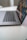 A sleek laptop is partially open on a clean, white surface, with a focus on the keyboard and touchpad. The screen displays a vibrant, digital image with abstract patterns.