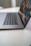 A sleek laptop is partially open on a clean, white surface, with a focus on the keyboard and touchpad. The screen displays a vibrant, digital image with abstract patterns.