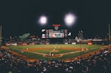 College baseball team mid-game, showcasing their sleek apace athletics caps and jerseys under bright stadium lights.