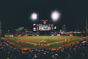 A panoramic view of a packed stadium under bright lights during a night game