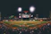 A team celebrating a home run under bright stadium lights with families cheering in the stands.