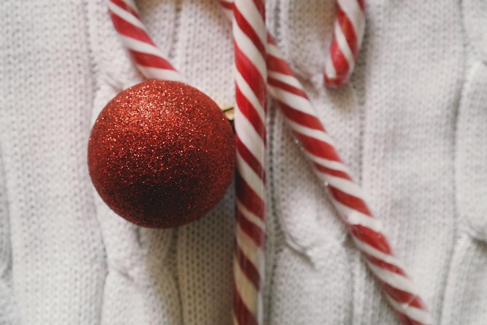 Two candy canes and a red XMAS ornament.