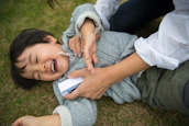 Smiling caregiver supporting a child during an interactive floor projection game.