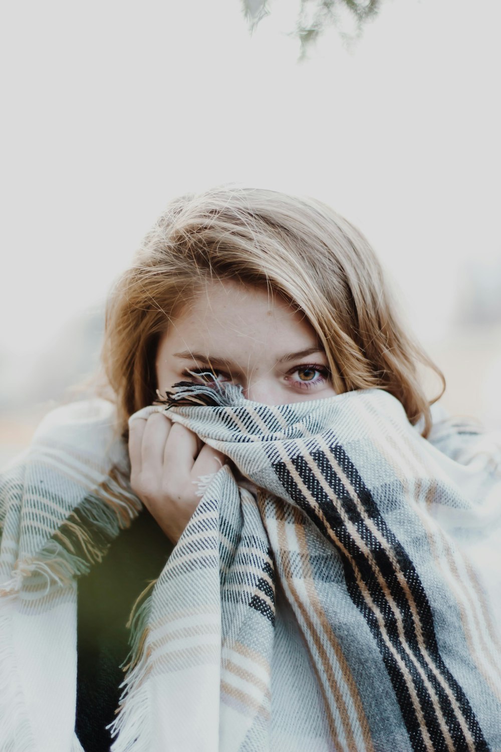woman hiding her face with scarf