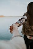 shallow focus photography of man and woman holding hands