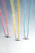 photograph of three plain releasing colorful smokes
