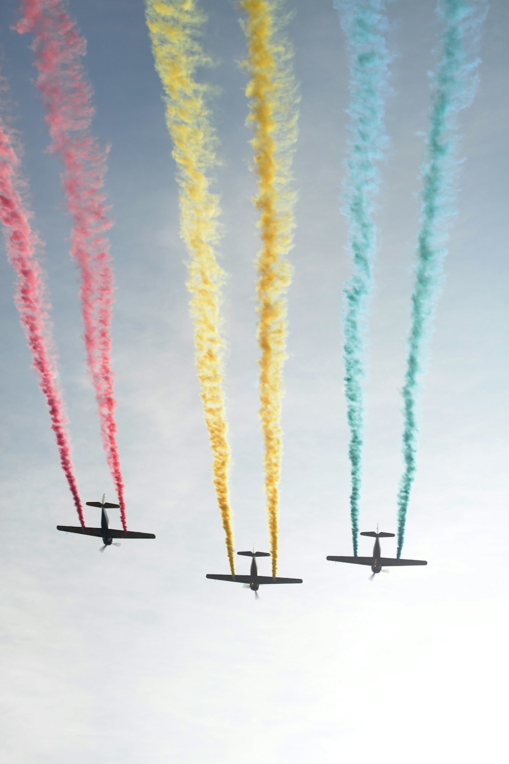 photograph of three plain releasing colorful smokes