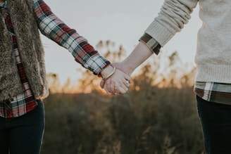 two person holding hands while standing