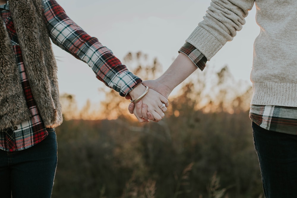 due persone che si tengono per mano in piedi