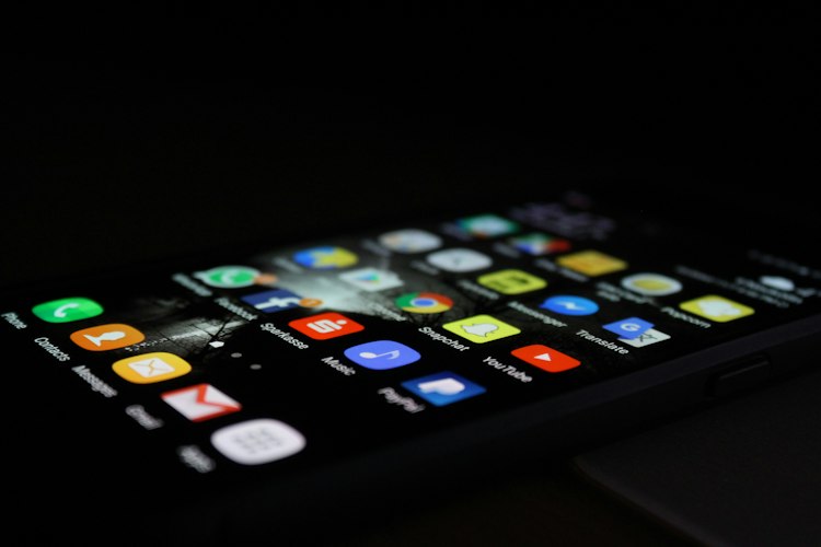 A close-up of a hand scrolling through a social media feed on a phone