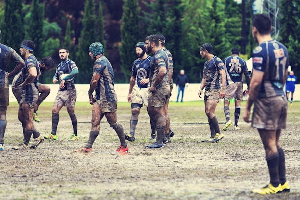 A group of classic rugby players training together on a grassy field.