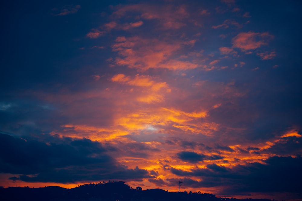 the sun is setting over a mountain range