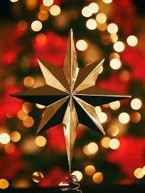 bokeh photography of gold star tree topper
