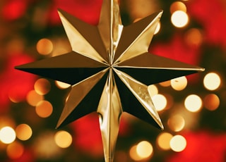 bokeh photography of gold star tree topper