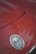 A close-up view of a red car's hood featuring the Chevrolet Corvette emblem, which includes the brand’s iconic crossed flags badge.