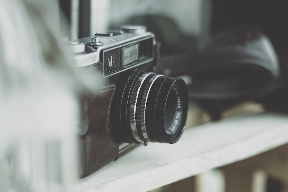 Fotografía de enfoque selectivo de la cámara en el estante de madera