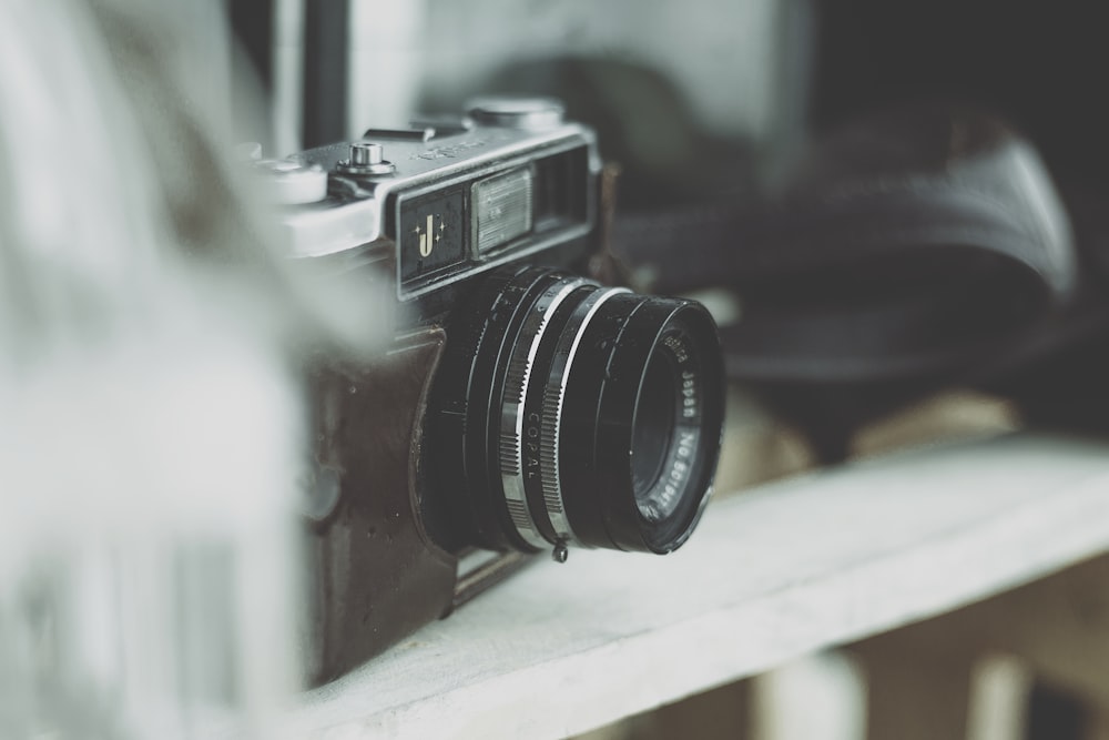 selective focus photography of camera on wooden rack