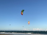 A panoramic view of colorful kites dotting the sky above the sparkling ocean near Mannar.
