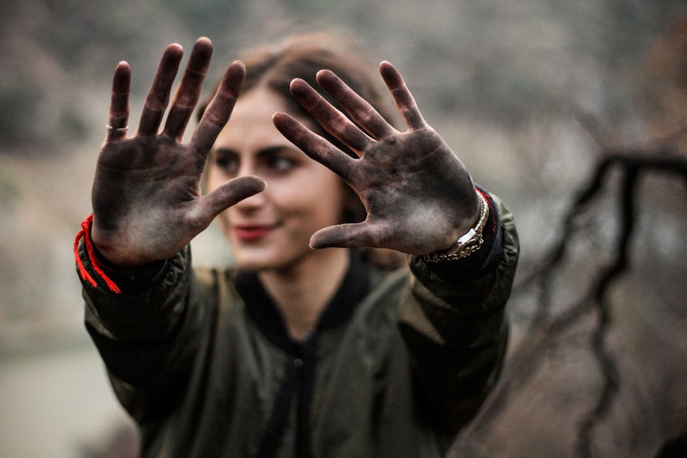 mulher mostrando suas mãos com tinta preta