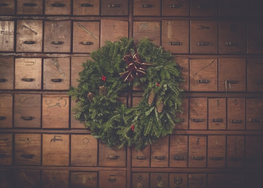 green and brown pinecone Christmas wreath on wooden drawers