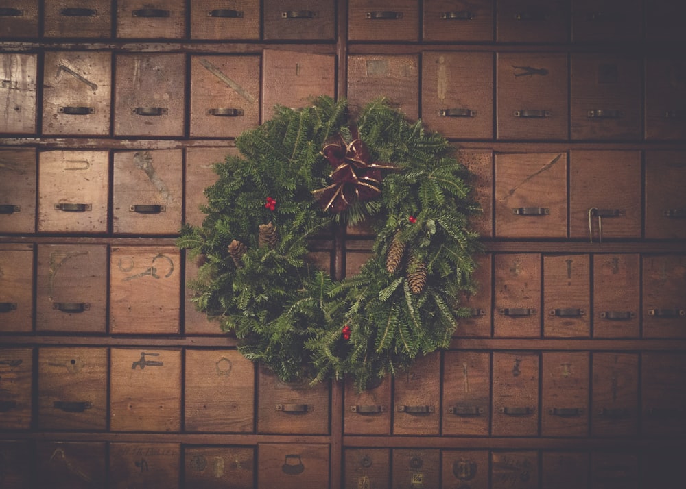 green and brown pinecone Christmas wreath on wooden drawers