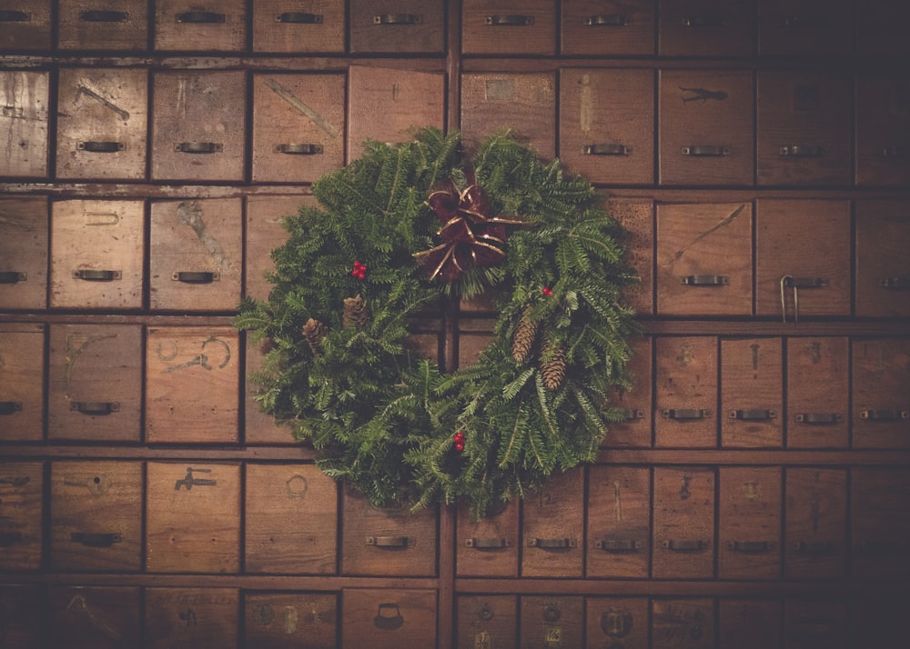 grüner und brauner Tannenzapfen-Weihnachtskranz auf Holzschubladen