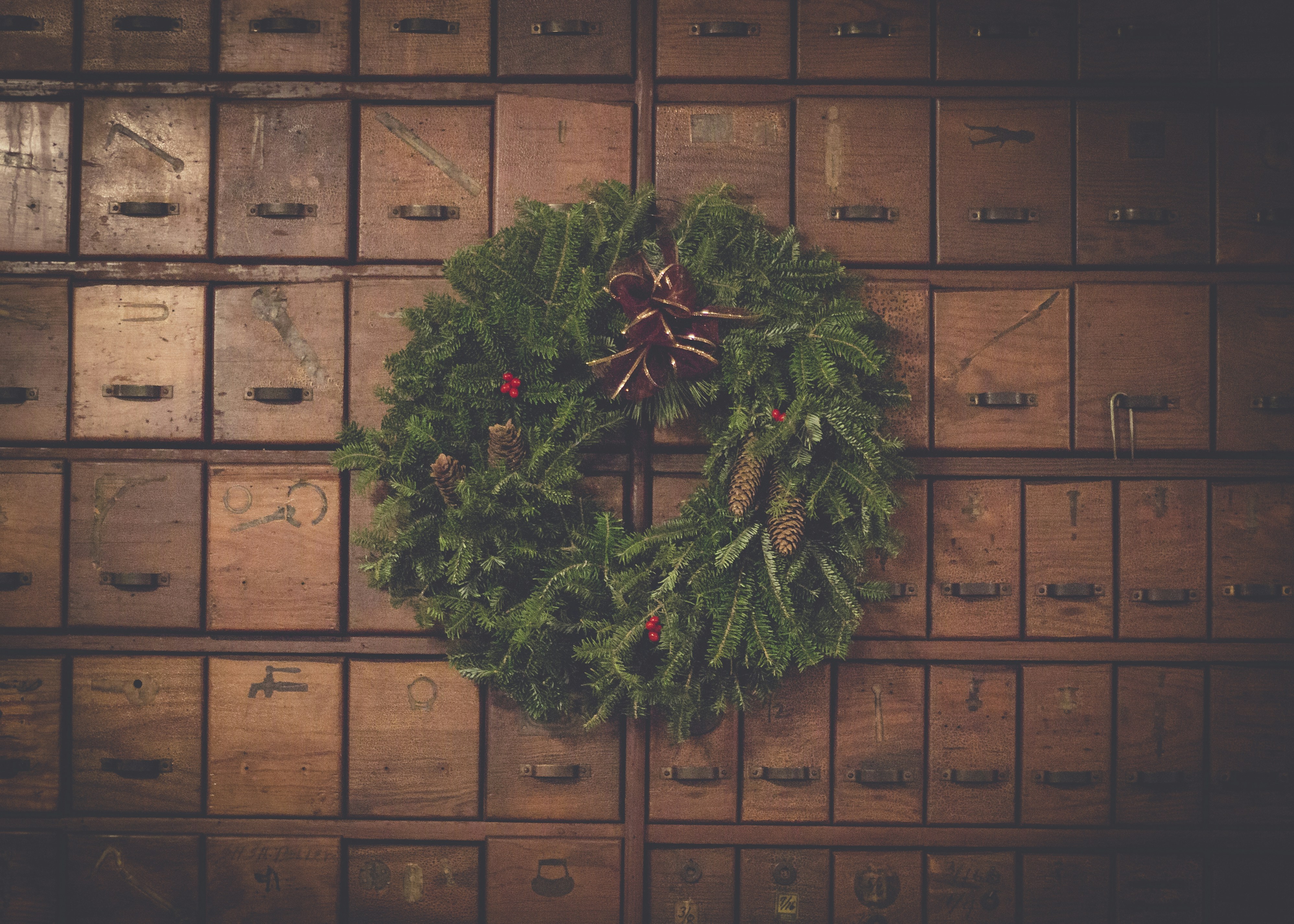 green and brown pinecone Christmas wreath on wooden drawers