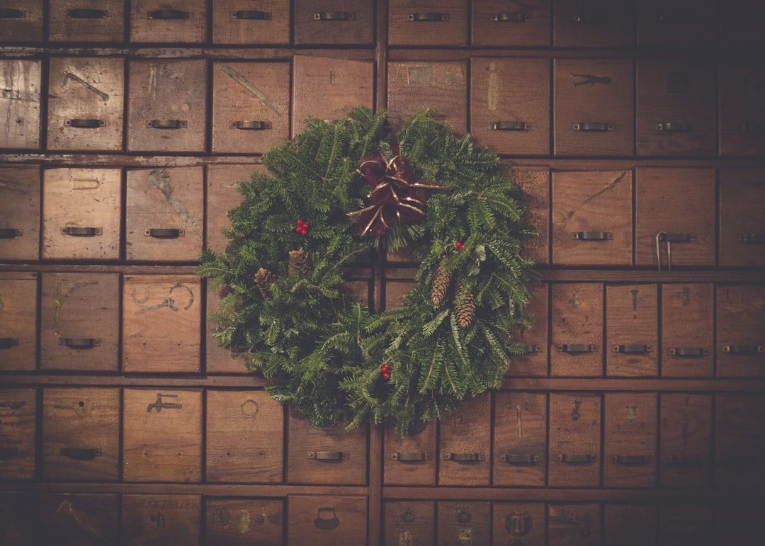 green and brown pinecone Christmas wreath on wooden drawers,