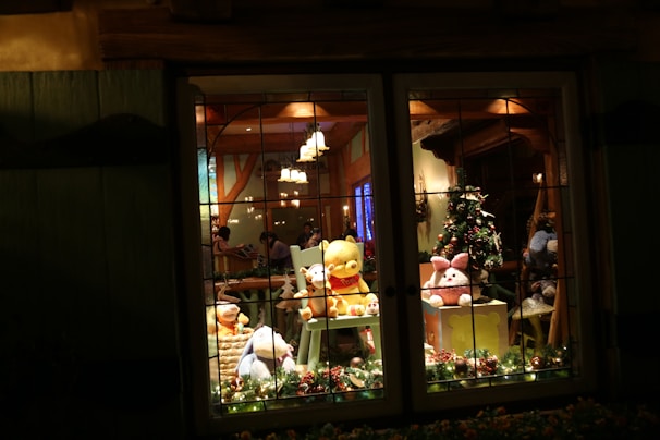 Santa Claus warmly greeting a group of joyful children in a cozy living room decorated with twinkling Christmas lights.