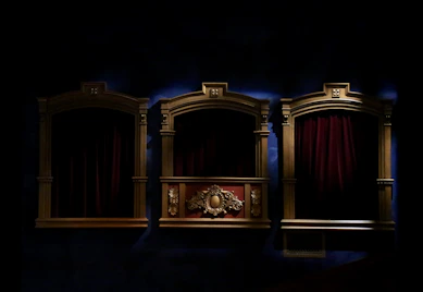 A collection of aged theater tickets and programs artistically arranged on a dark velvet backdrop