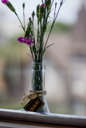 Elegant glass bottles of essential oils with fresh flowers and soft lighting.