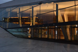 Evening shot of a minimalist home with warm interior lighting contrasting the cool concrete exterior.