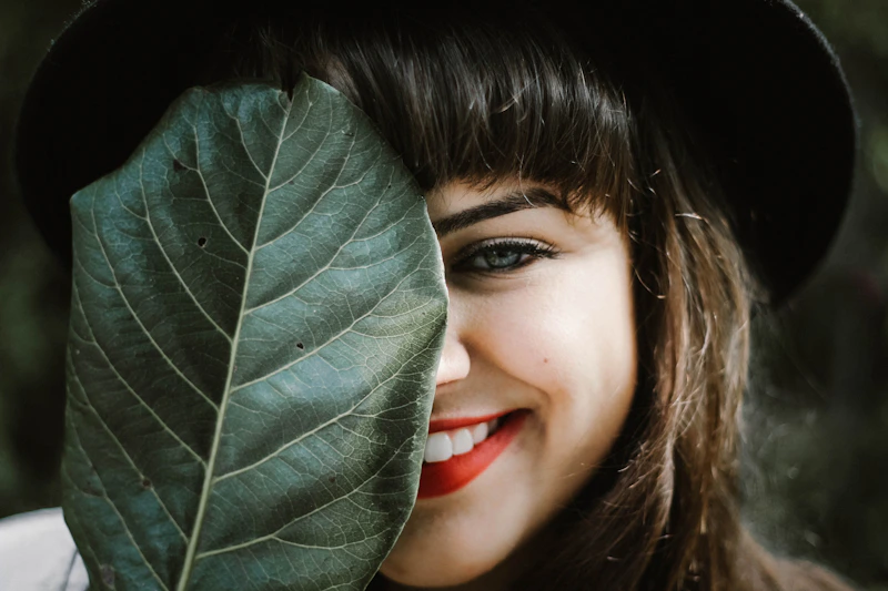 mature woman holding a leaf outdoors