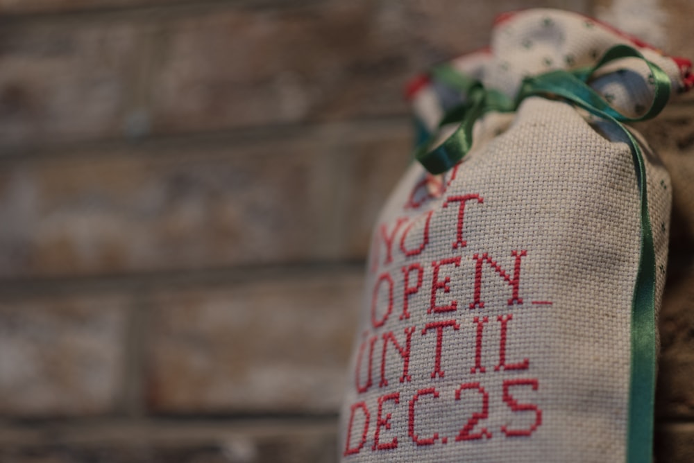 a bag with a message on it hanging on a brick wall