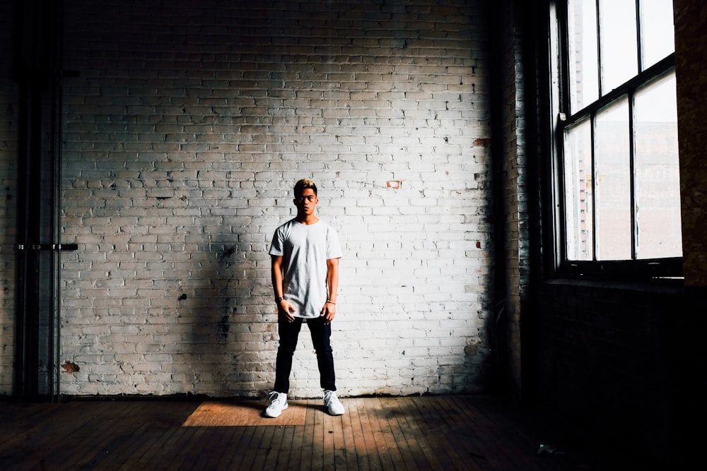 man standing in front of white wall