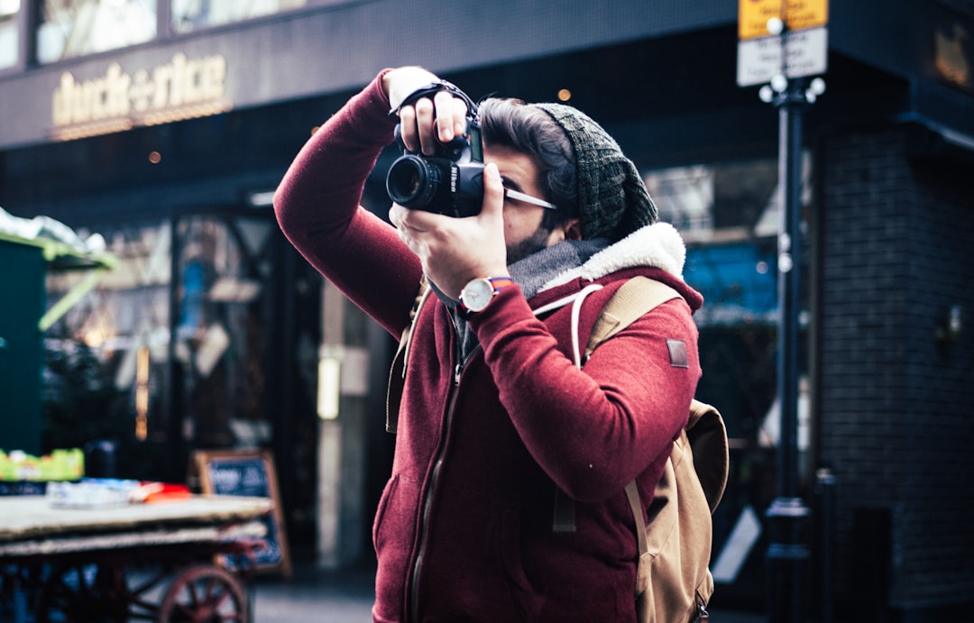 man taking a photo near storefront