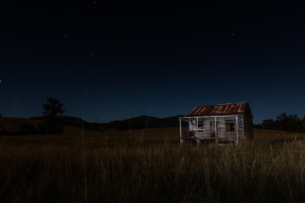 gray and brown wooden house surrounded by grass near mountain