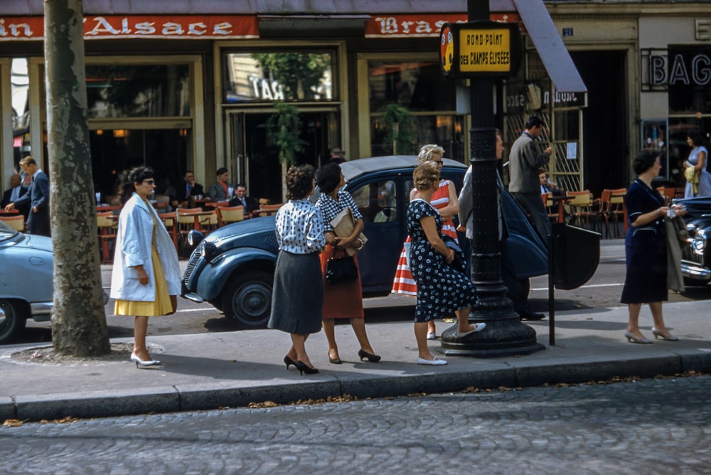 female women standing near black pole